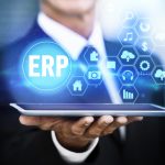 Man holding tablet screen in hand with logos showing ERP ad connectivity in Salesforce Consulting company