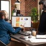 Power apps developer explaining app functioning with dashboard to team member